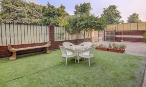 a patio with two chairs and a table and a bench at Itsy By Treebo - City Centre Noida in Noida