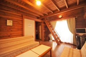 a living room with a staircase in a wooden house at Cottage&Pension Love Thirty in Karuizawa