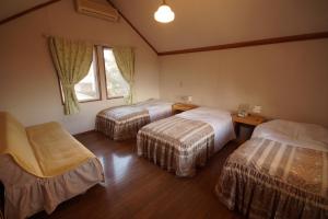 a hotel room with two beds and a window at Cottage&Pension Love Thirty in Karuizawa