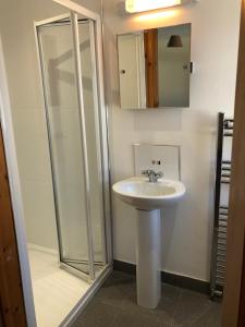 une salle de bain avec un lavabo et une douche dans l'établissement Tavnaghoney Cottages, à Cushendall 158 autres photos