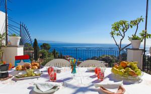 un tavolo con cibo sopra con vista sull'oceano di Casa Stella del Mattino a Taormina Altre 14 foto