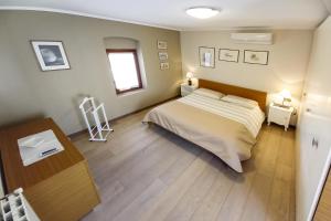 ein Schlafzimmer mit großem Bett und Holzboden in der Unterkunft Case Vacanze ai Burattini in Adrara San Rocco