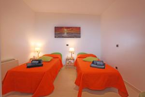 2 camas en una habitación con sábanas de color naranja en Casa Stella del Mattino en Taormina