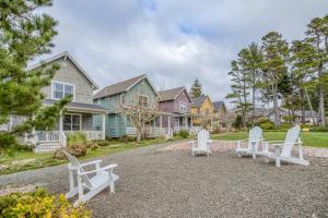 a group of white chairs sitting on the gravel in front of houses at HipNautic in Depoe Bay