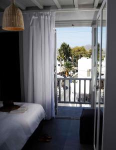 a bedroom with a bed and a door to a balcony at Mykonos Loft in Mýkonos City
