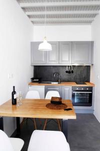 una cucina con tavolo in legno e armadietti bianchi di Mykonos Loft a Mykonos Città