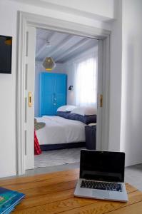 una camera con un letto e un computer portatile su un tavolo di Mykonos Loft a Mykonos Città