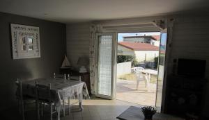 uma sala de jantar com uma mesa e uma porta de vidro deslizante em Appartement Pour 4 Personnes Dans Villa Dans Le Vent em Hossegor