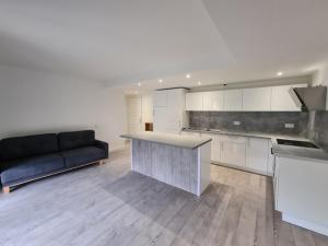 uma cozinha com um sofá e um balcão num quarto em Appartement Golf International de la Baule em Saint-André-des-Eaux