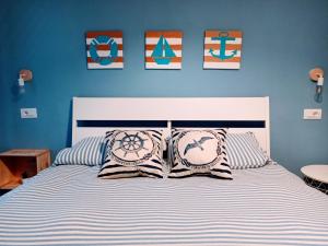 een slaapkamer met een bed met blauwe muren en kussens bij Mandracchio Central Apartment in Grado