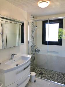 ein Bad mit einem Waschbecken und einer Dusche in der Unterkunft Villa La Plage Pour 7 Personnes A Proximite Du Port De Plaisance in Capbreton