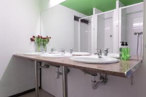 Un baño con tres lavabos y un espejo grande. en Diagonal House Hostel, en Barcelona 44 fotos más