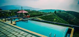 a swimming pool with a view of a vineyard at Palette Hill View Resorts Vagamon in Vagamon