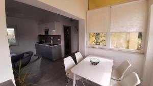 a white kitchen with a white table and chairs at Holiday House Romi in Pula