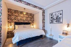 a bedroom with a large bed with a floral accent wall at Villa Park Plitvice in Rakovica