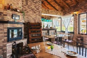 a dining room with tables and chairs and a fireplace at Villa Park Plitvice in Rakovica