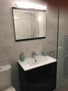 een badkamer met een wastafel, een toilet en een spiegel bij CALM HOUSE in Sóller