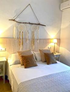 una camera da letto con letto, lenzuola e cuscini bianchi di CALM HOUSE a Sóller