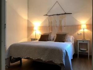 een slaapkamer met een groot bed met 2 tafels en 2 lampen bij CALM HOUSE in Sóller