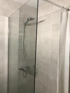 een douche met een glazen deur in de badkamer bij CALM HOUSE in Sóller