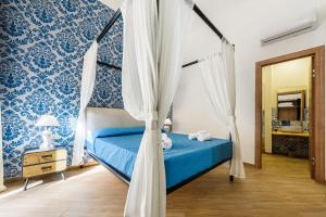 sypialnia z łóżkiem z niebiesko-białą tapetą w obiekcie Incao Holiday I Pupi House w Cefalù