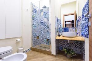 y baño con ducha, aseo y lavamanos. en Incao Holiday I Pupi House, en Cefalú