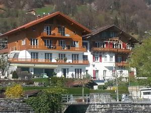 a large building on a hill next to a river at Brienzersee in Brienz