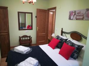 1 dormitorio con 1 cama grande con almohadas rojas y blancas en Luna lunera, en Biescas