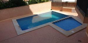 una piscina con agua azul en un patio trasero en FMM Apartamentos Magic Finestrat Benidorm Holidays, en Cala de Finestrat