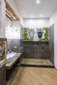 a bathroom with a sink and a shower with mosaic tiles at Incao Holiday Il Moro House in Cefalù