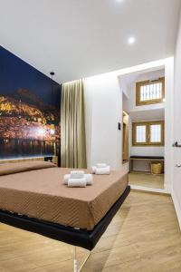 een slaapkamer met een groot bed en handdoeken bij Incao Holiday Il Moro House in Cefalù