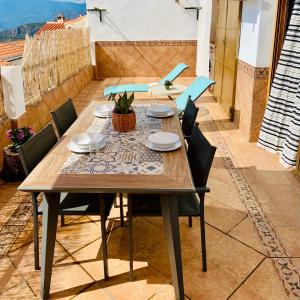 Une table et des chaises en bois sont disponibles sur la terrasse. dans l'établissement Ático Lanjarón, à Lanjarón