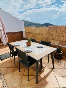 a table and chairs sitting on a patio at Ático Lanjarón in Lanjarón +17 photos