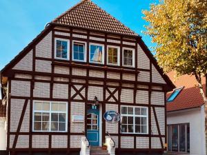 a half timbered house with a blue door at Kajüthus Apartment 6 in Fehmarn