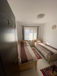 sypialnia z 2 łóżkami i oknem w obiekcie Casa Mărguța w Jassach