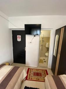 a room with two beds and a door to a bathroom at Casa Mărguța in Iaşi