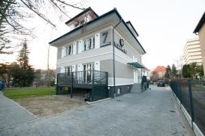 een wit gebouw met een balkon in een straat bij Villa Meteo in Kołobrzeg