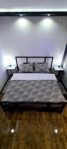 a large bed in a bedroom with two lamps at Fantastic Place in Apatin