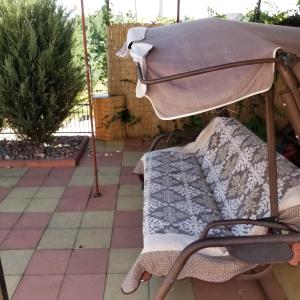 un patio con sombrilla y un sofá debajo. en Дача в Санжейке с уютной территорией для отдыха у Чёрного моря en Sanzhiyka