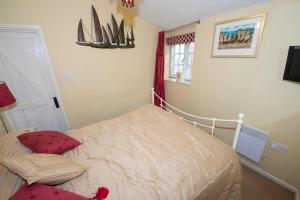 a small bedroom with a bed and a window at 1 bedroomed Cottage near quay in Blakeney