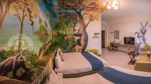 a bedroom with a mural of trees and animals at Rabbit Forest B&B in Ruisui