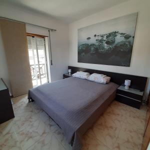 a bedroom with a bed and a large painting on the wall at Apartamento Santa Cruz in Santa Cruz