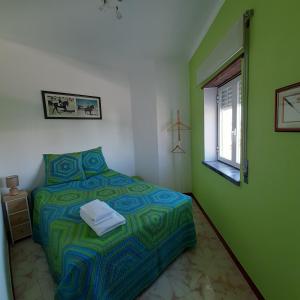 zieloną sypialnię z łóżkiem i oknem w obiekcie Apartamento Santa Cruz w mieście Santa Cruz