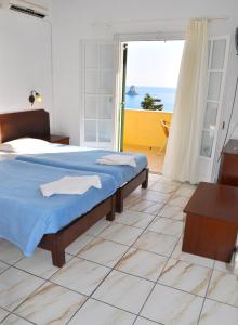 a bedroom with a bed and a view of the ocean at Holiday Apartments Maria with Pool and Panorama View - Agios Gordios Beach in Agios Gordios