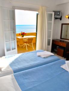 a bedroom with a bed and a view of the ocean at Holiday Apartments Maria with Pool and Panorama View - Agios Gordios Beach in Agios Gordios