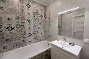 a bathroom with a tub and a sink and a bath tub at Комфортна та тиха квартира у Центрі міста in Ternopilʼ