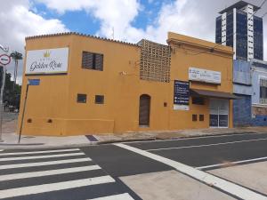 a yellow building on the corner of a street at GOLDEN ROSE HOTEL in Campinas