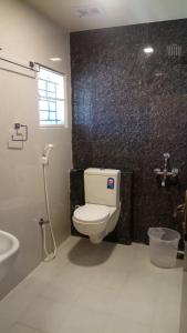 a bathroom with a toilet and a sink at Faiz Residency in Rāmanāthapuram