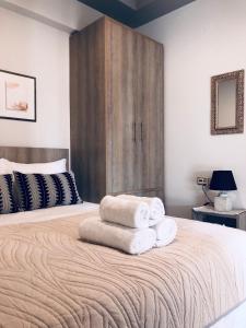 1 dormitorio con 1 cama grande y toallas. en Xenia_Apartments A5, en Kozani