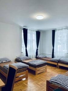 a room with four beds in it with windows at Apartament 1 dla 6 osób in Bielsko-Biała